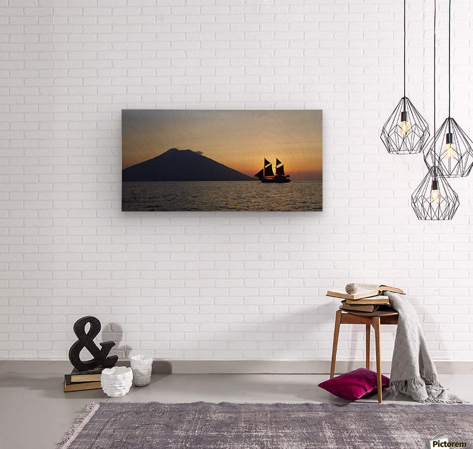 Ocean view with yacht with sails and volcano silhouetted against the setting sun  Wood print